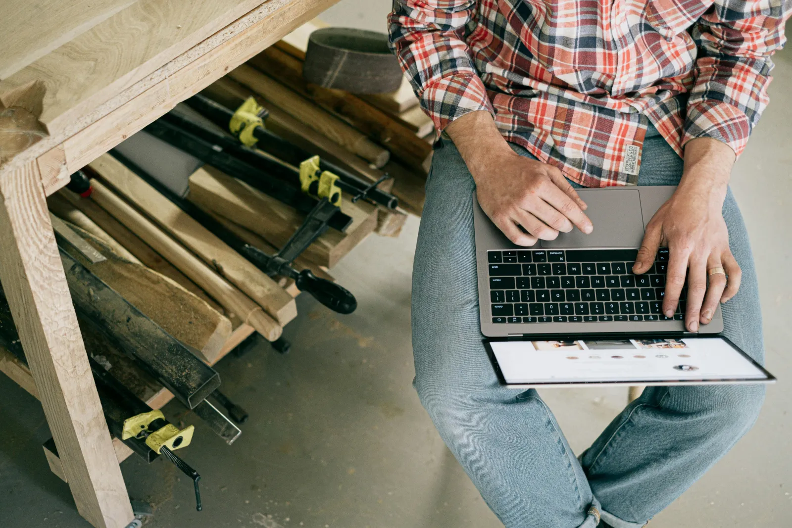 Håndverker som bruker en laptop i et verksted